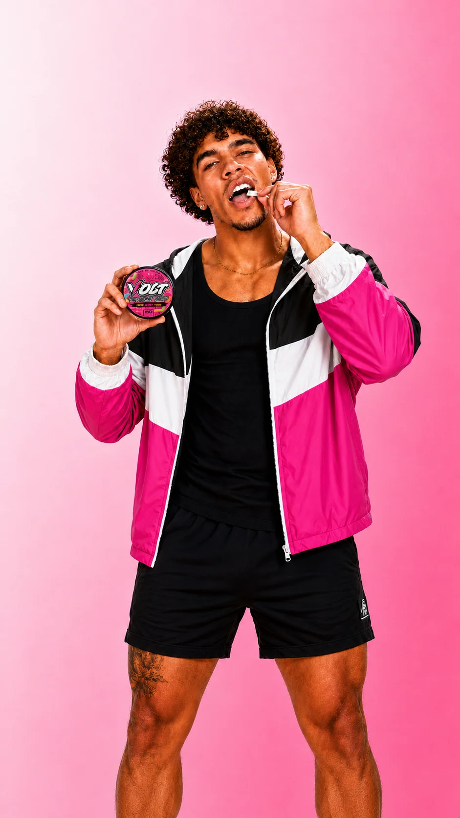Athlete in a pink, blue and white windbreaker placing a VOLT Sour Gummy Worm pouch in his lip while holding the can