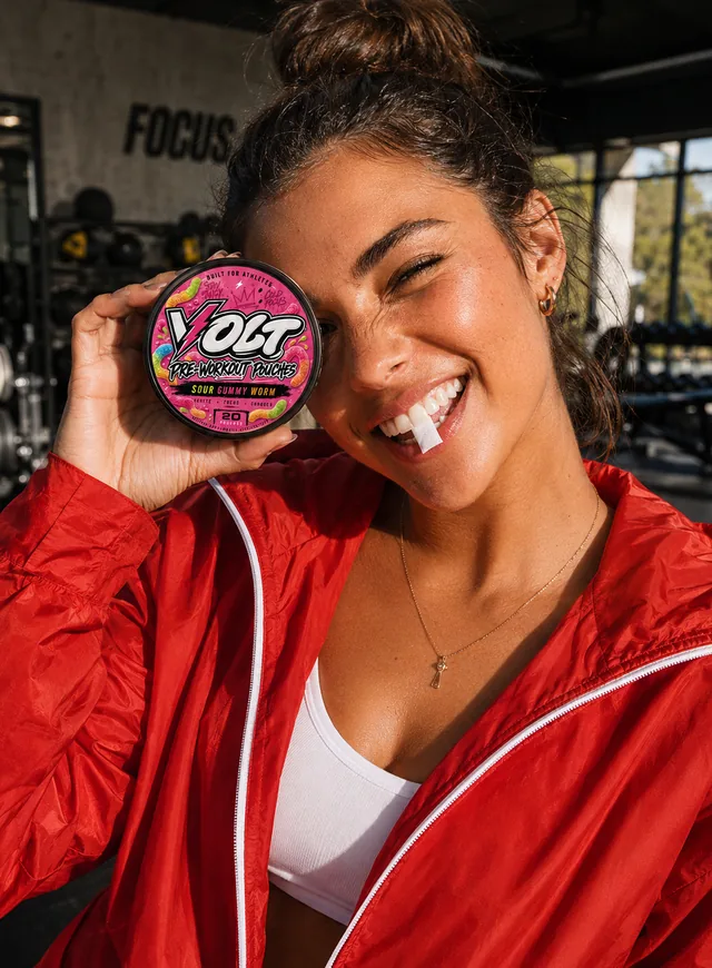 Athlete with VOLT Sour Gummy Worm using a pouch at the gym